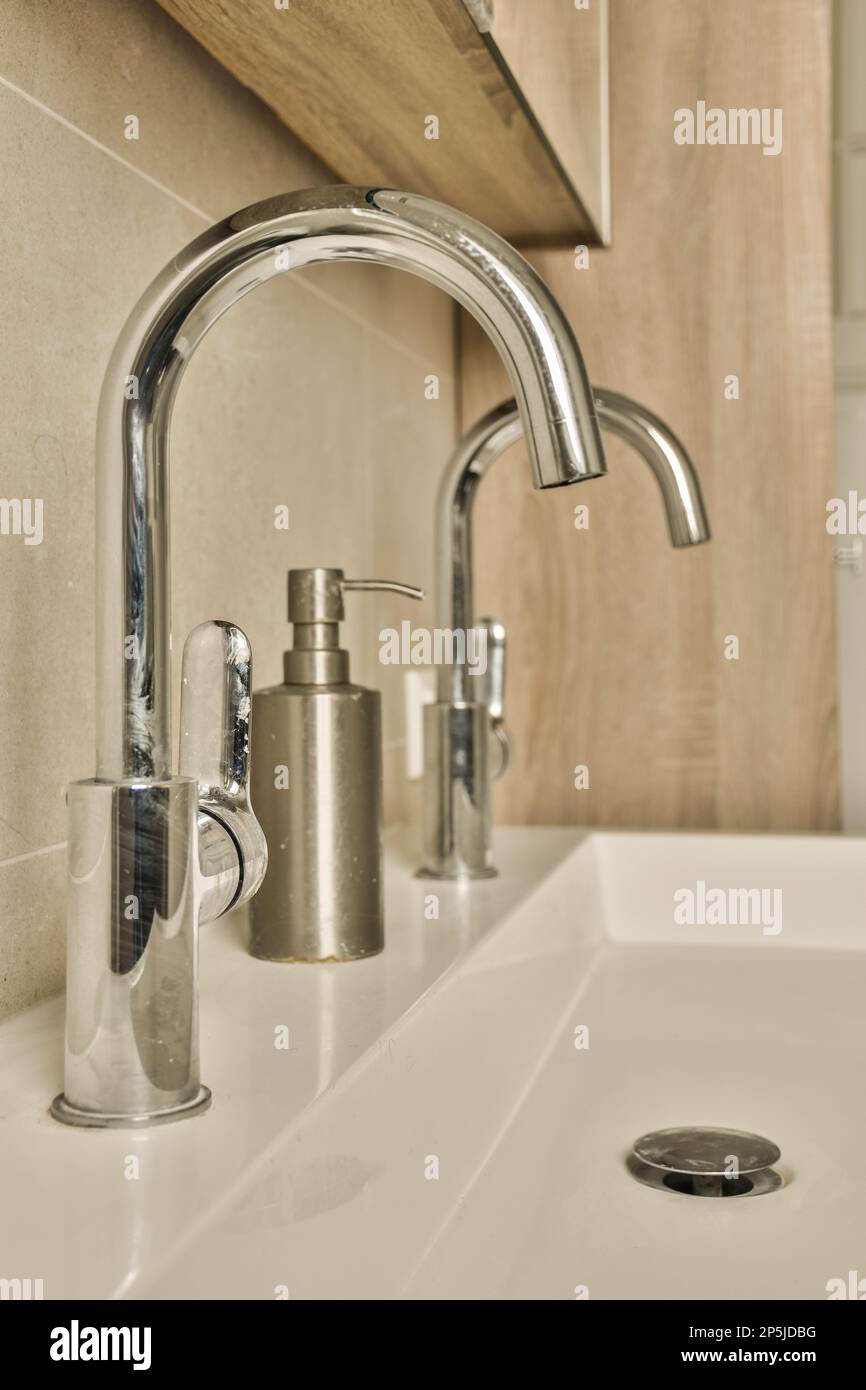 a bathroom sink with soap dispenser and toothbrushs on the counter in