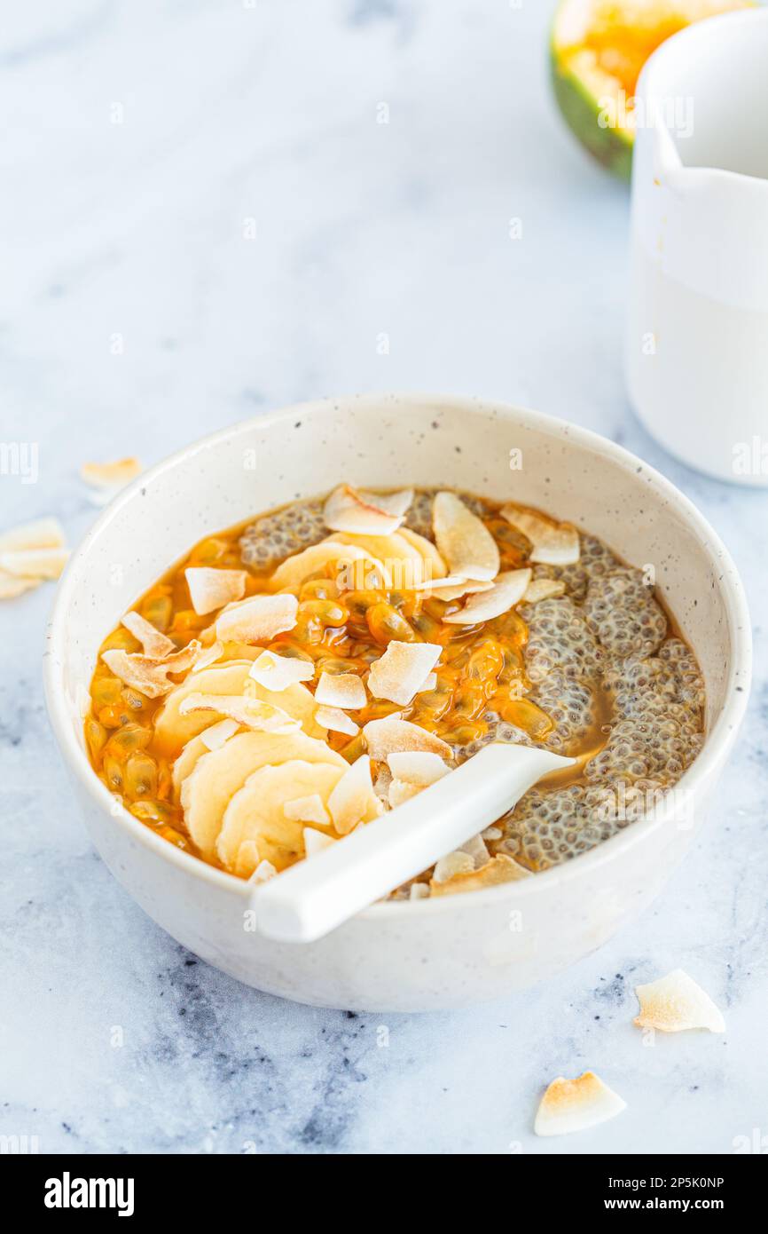 Chia pudding with passion fruit, coconut and coconut yogurt in white bowl. Healthy vegan recipe. Stock Photo