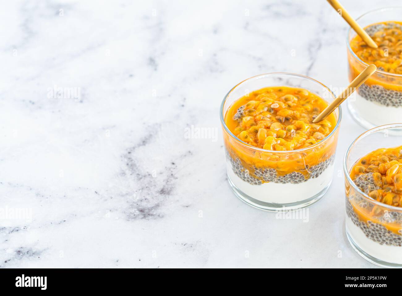 Chia pudding with passion fruit and coconut yogurt in a glasses, copy space. Healthy vegan recipe. Stock Photo