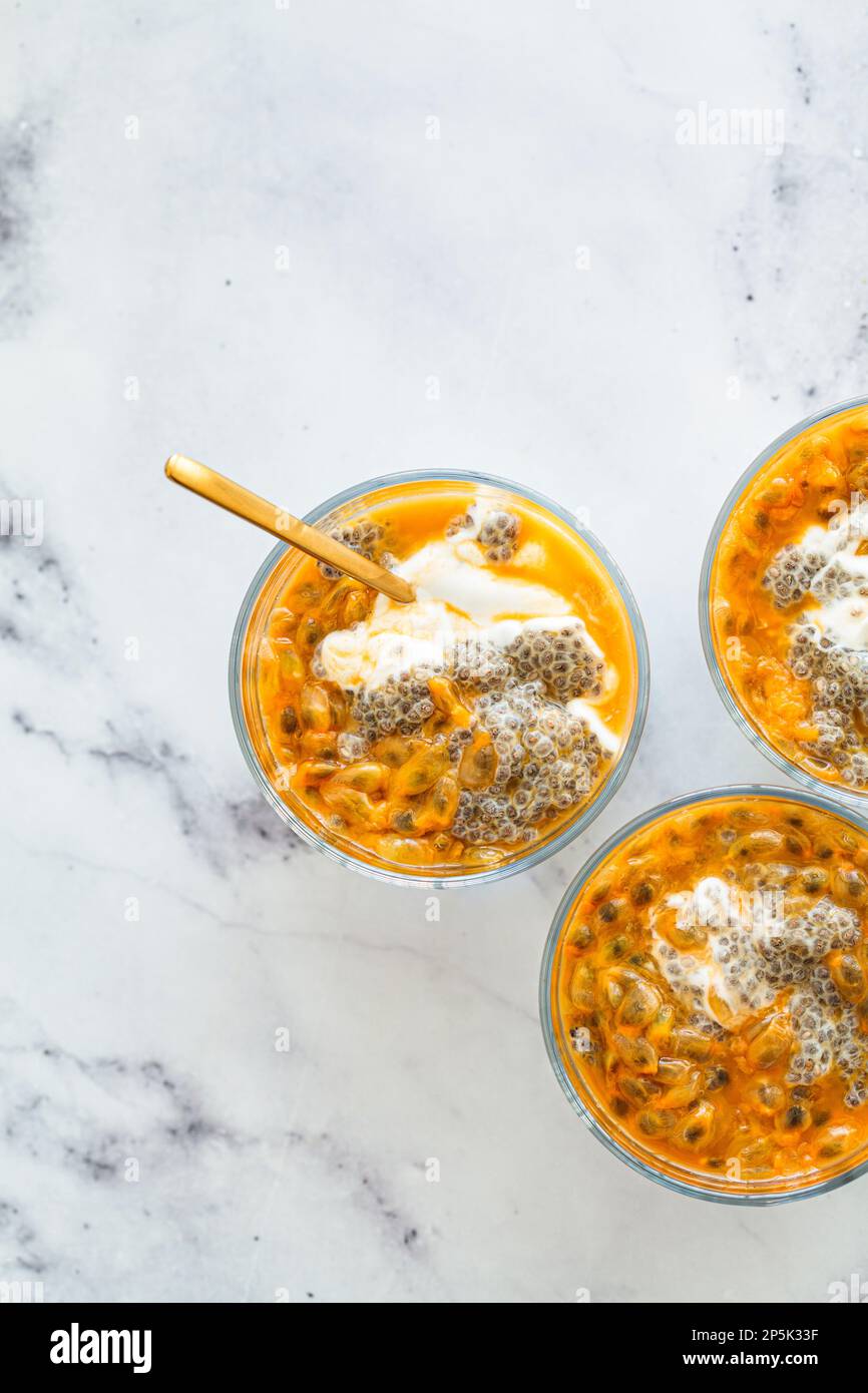 Chia pudding with passion fruit and coconut yogurt in a glass. Healthy vegan recipe. Stock Photo