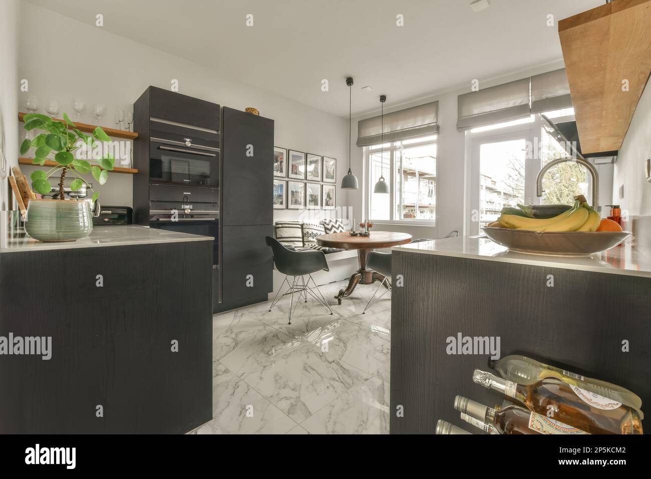 a kitchen with black cabinets and white marble flooring in the center ...