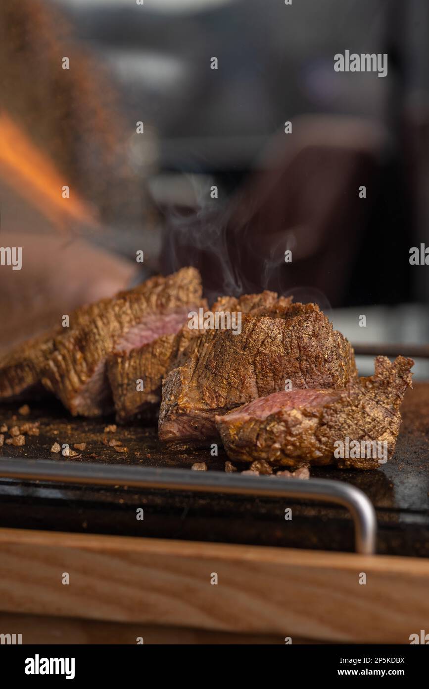 Cooking beef tenderloin steak on black stone with copy space for text