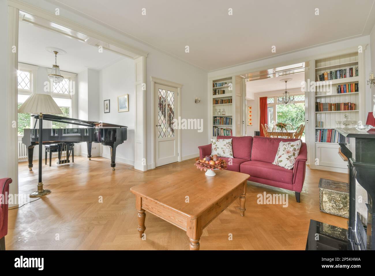 a living room with a piano in the middle and a grand piano on the other ...