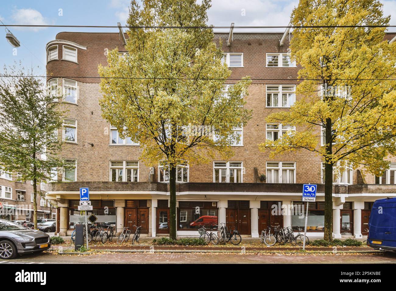an apartment building with bicycles parked on the street next to it and ...