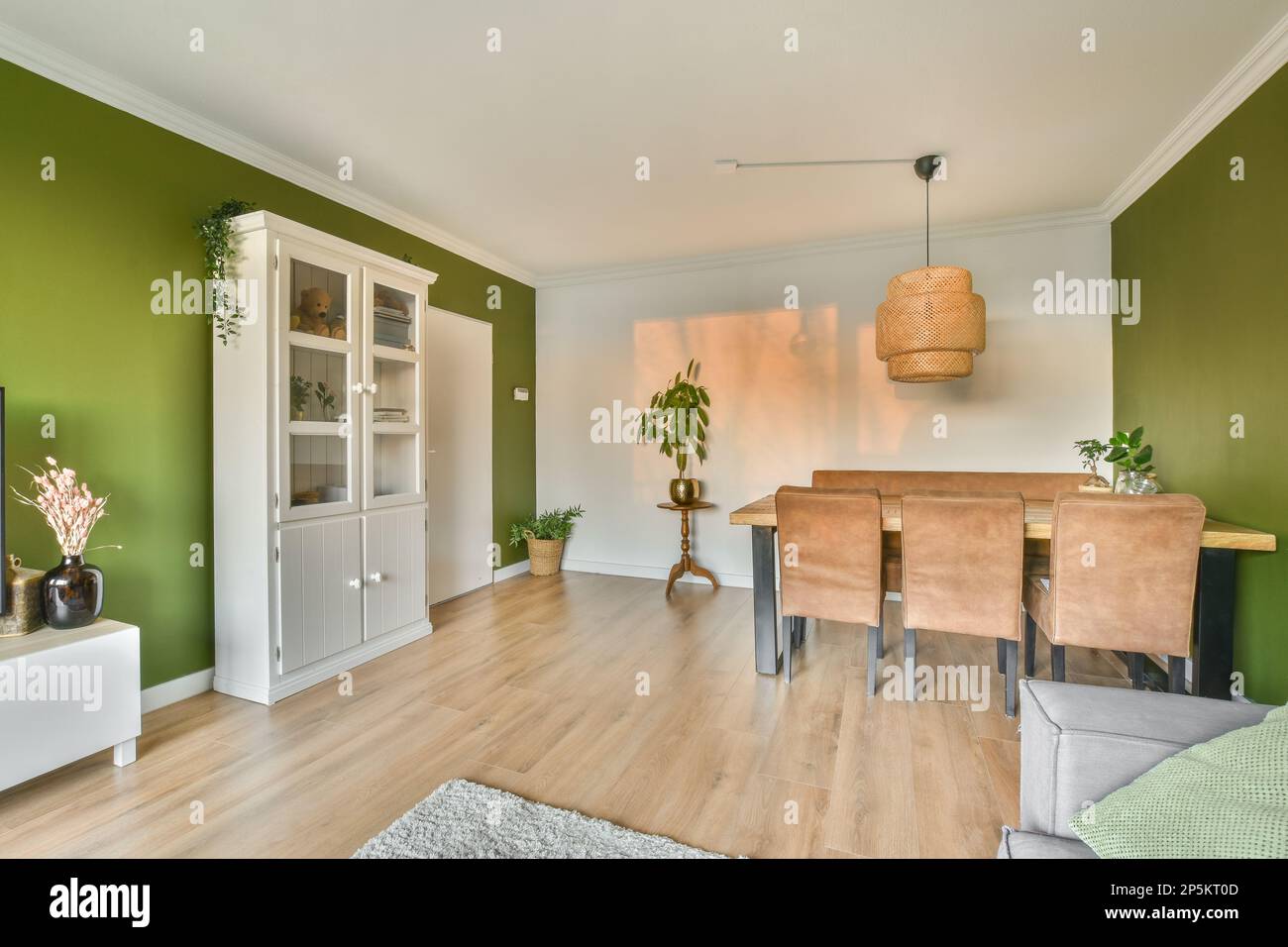 a living room with green walls and hardwood flooring, including a small ...