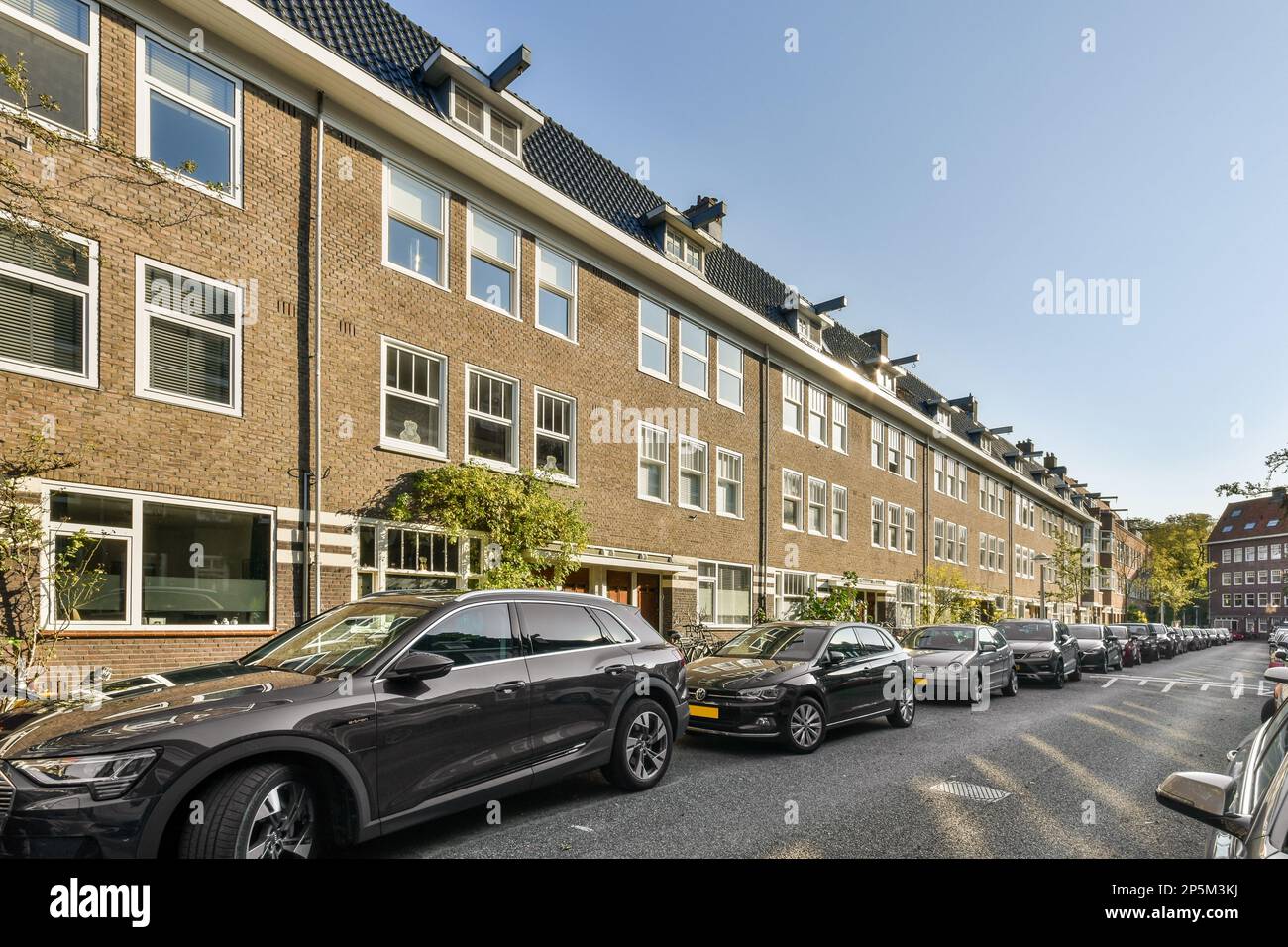 cars parked on the street in front of a brick building with many ...