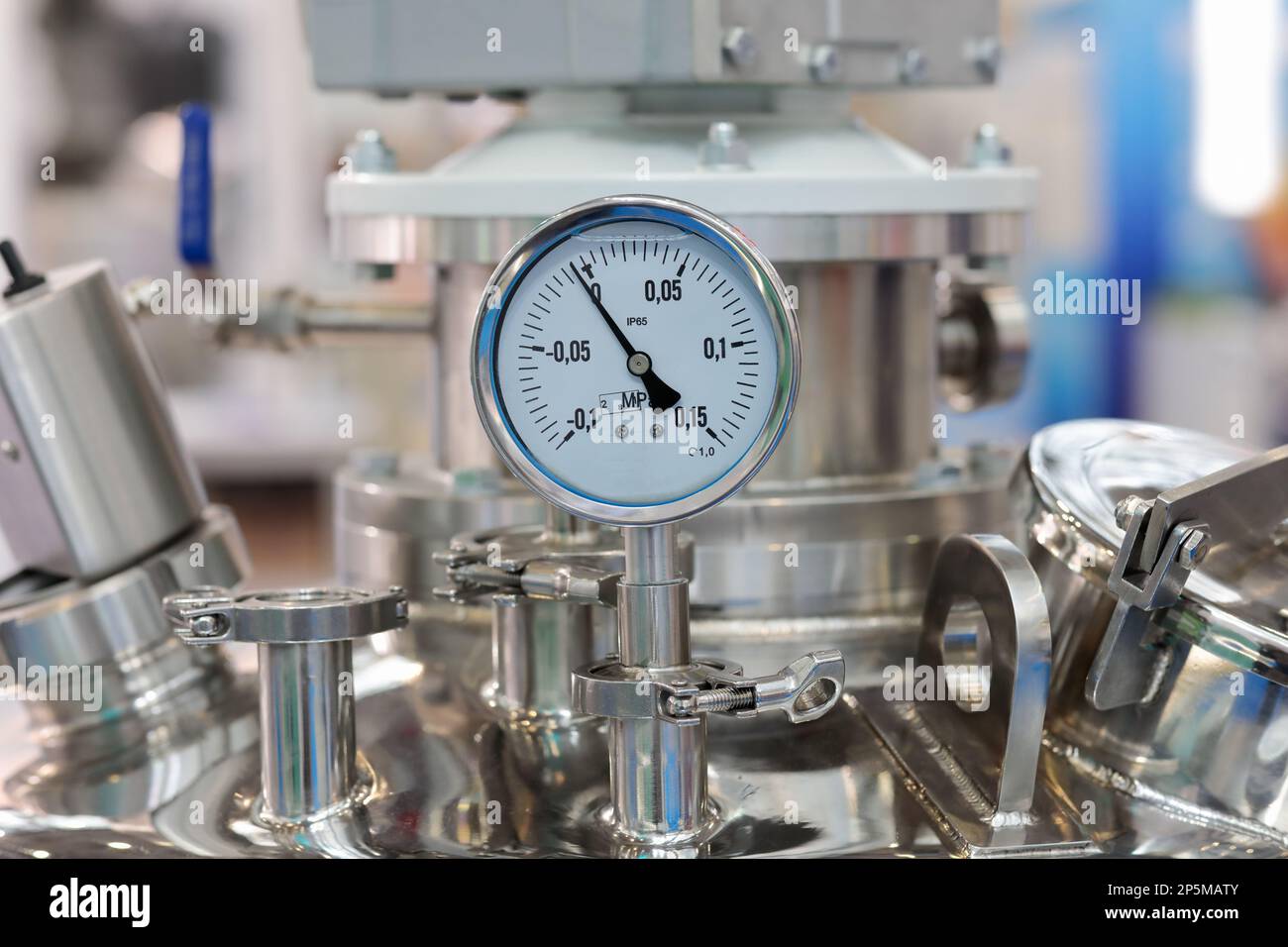 Stainless steel industrial chemical reactor with pressure gauge. Selective focus. Stock Photo