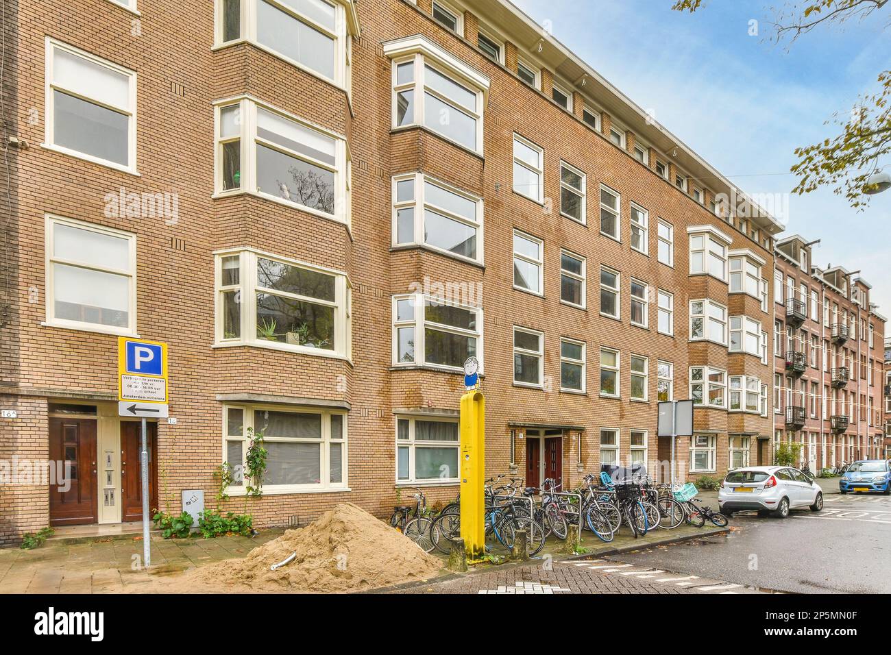 an apartment building with bicycles parked on the street next to it and ...