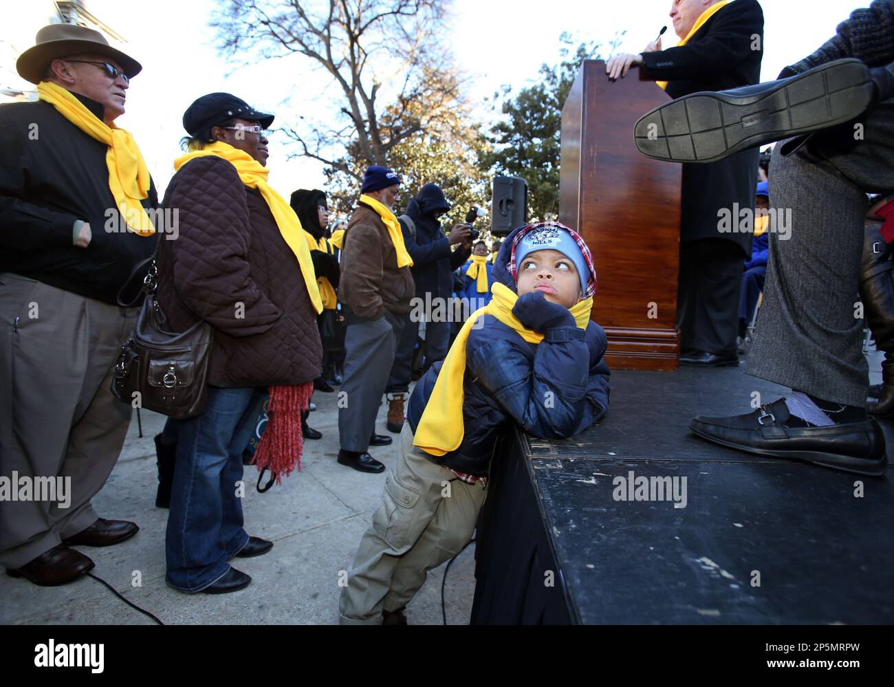 Solomon Dean, 7, of Austell, looks back at his mother, Edith Dean, as he waits during a speaker's presentation during the fourth annual Georgia School Choice Celebration and Rally at the west entrance to the Capitol Thursday, Jan. 31, 2013, in Atlanta. More than 2,000 public, private, and home school students met outside the Georgia State Capitol Thursday to call for the expansion of educational opportunities for kids. (AP Photo/Atlanta Journal-Constitution, Jason Getz) MARIETTA DAILY OUT; GWINNETT DAILY POST OUT; LOCAL TV OUT; WXIA-TV OUT; WGCL-TV OUT Stock Photo