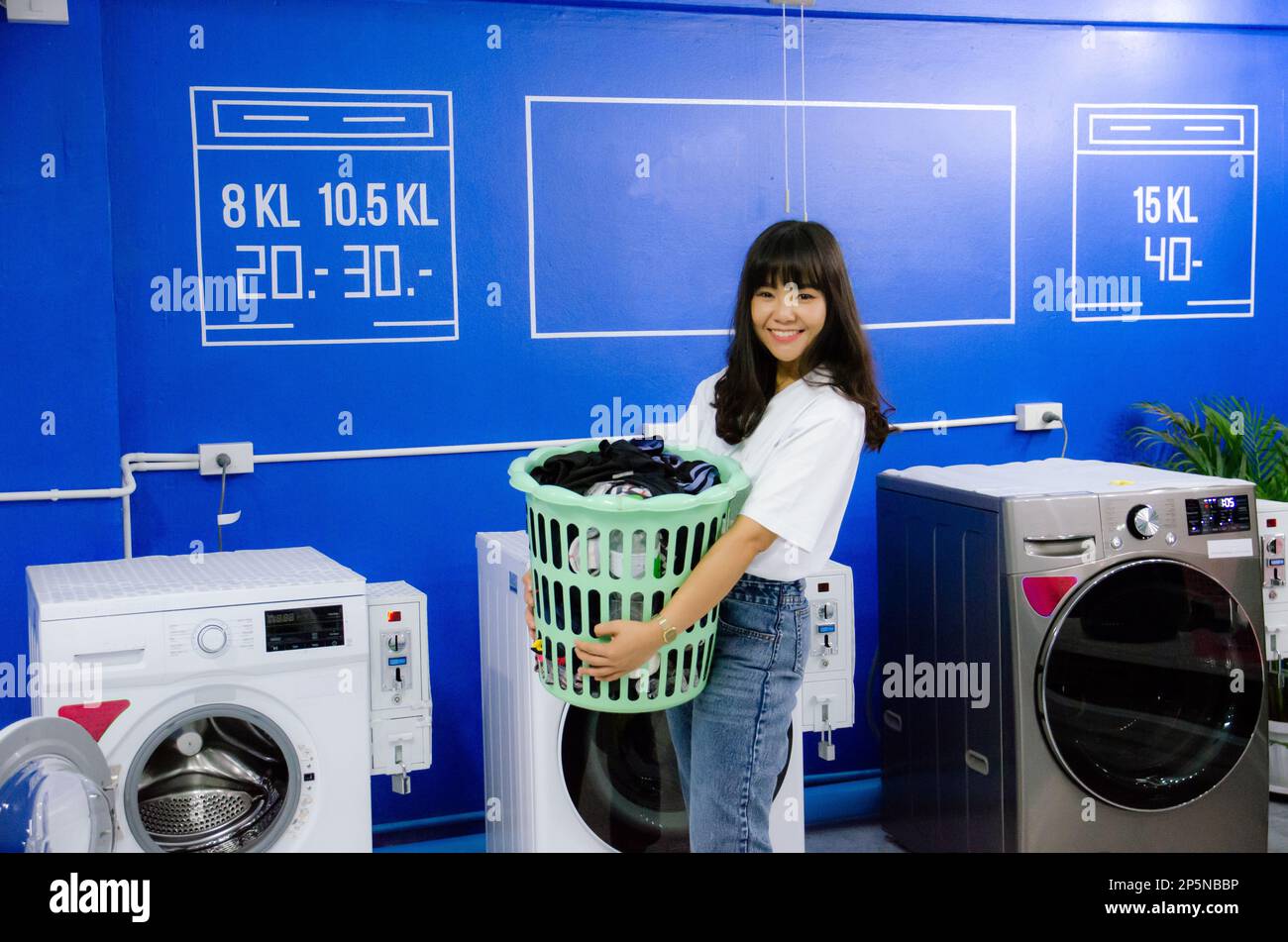 Asian girl is holding basket in laundry shop with smile face Stock Photo Alamy