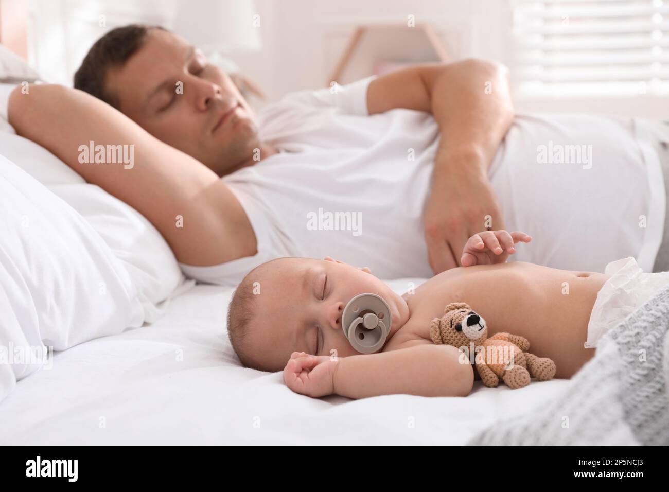 Father with his cute baby sleeping in bed at home Stock Photo Alamy