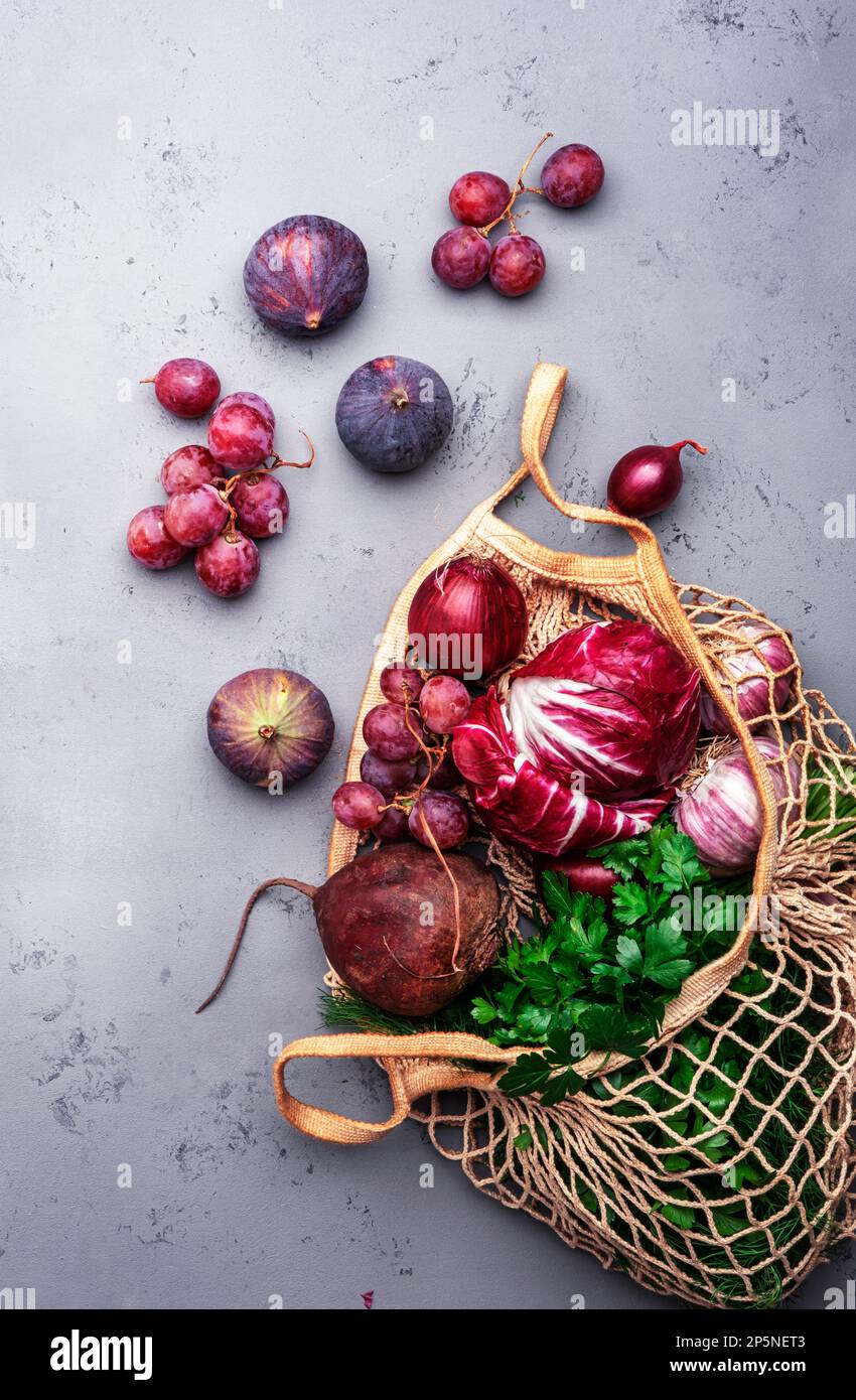 Food background with purple vegetables, roots and fruits in string ...