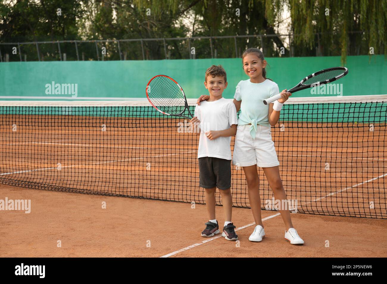 Kids With Rackets Happy children with tennis rackets on court outdoors Stock Photo - Alamy
