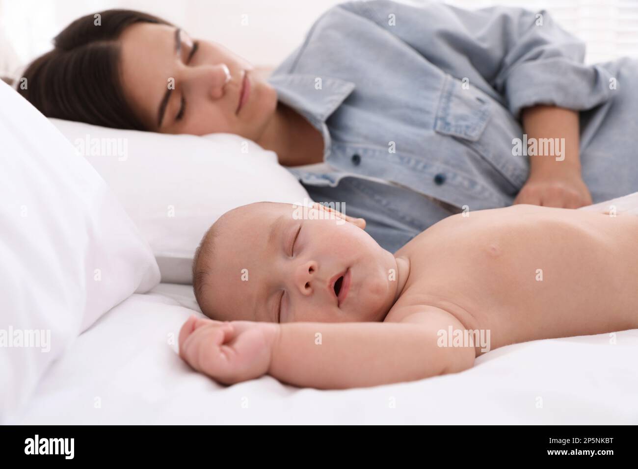 Mother with her cute baby sleeping in bed Stock Photo Alamy