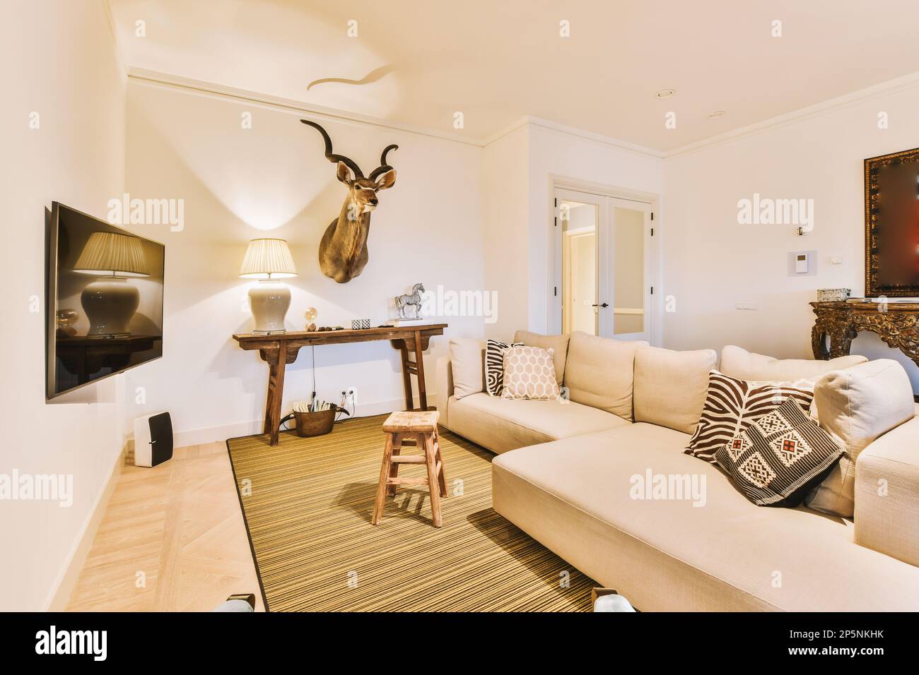 a living room with a deer head mounted on the wall above the couch and