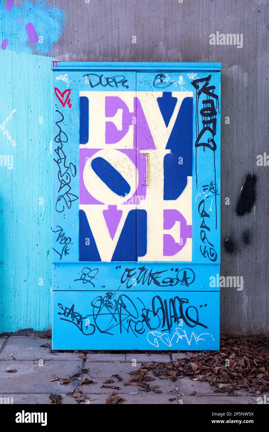 For editorial use only: EVOLVE. A mural graffiti homage to Robert Indiana on a street cabinet by Plan B in Itä-Pasila district of Helsinki, Finland. Stock Photo