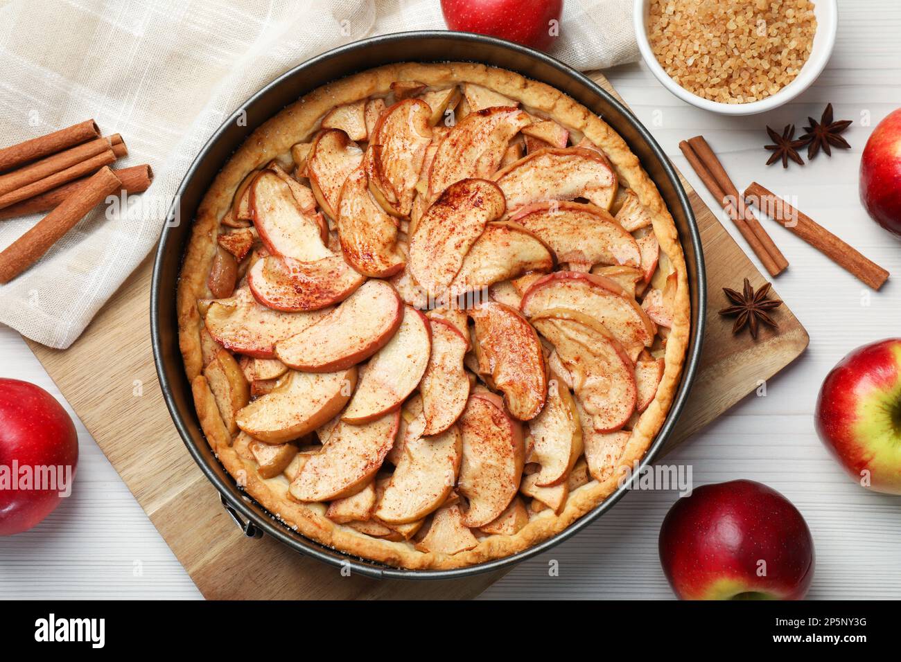 Delicious apple pie and ingredients on white wooden table, flat lay Stock Photo