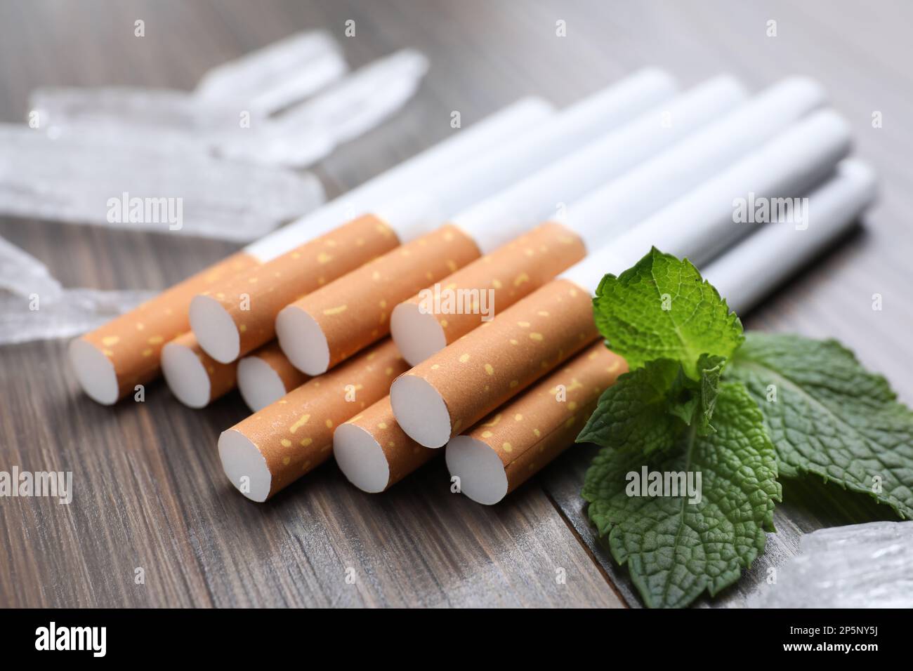 vicks cigarette Cigarettes, menthol crystals and mint on wooden table, closeup Stock Photo