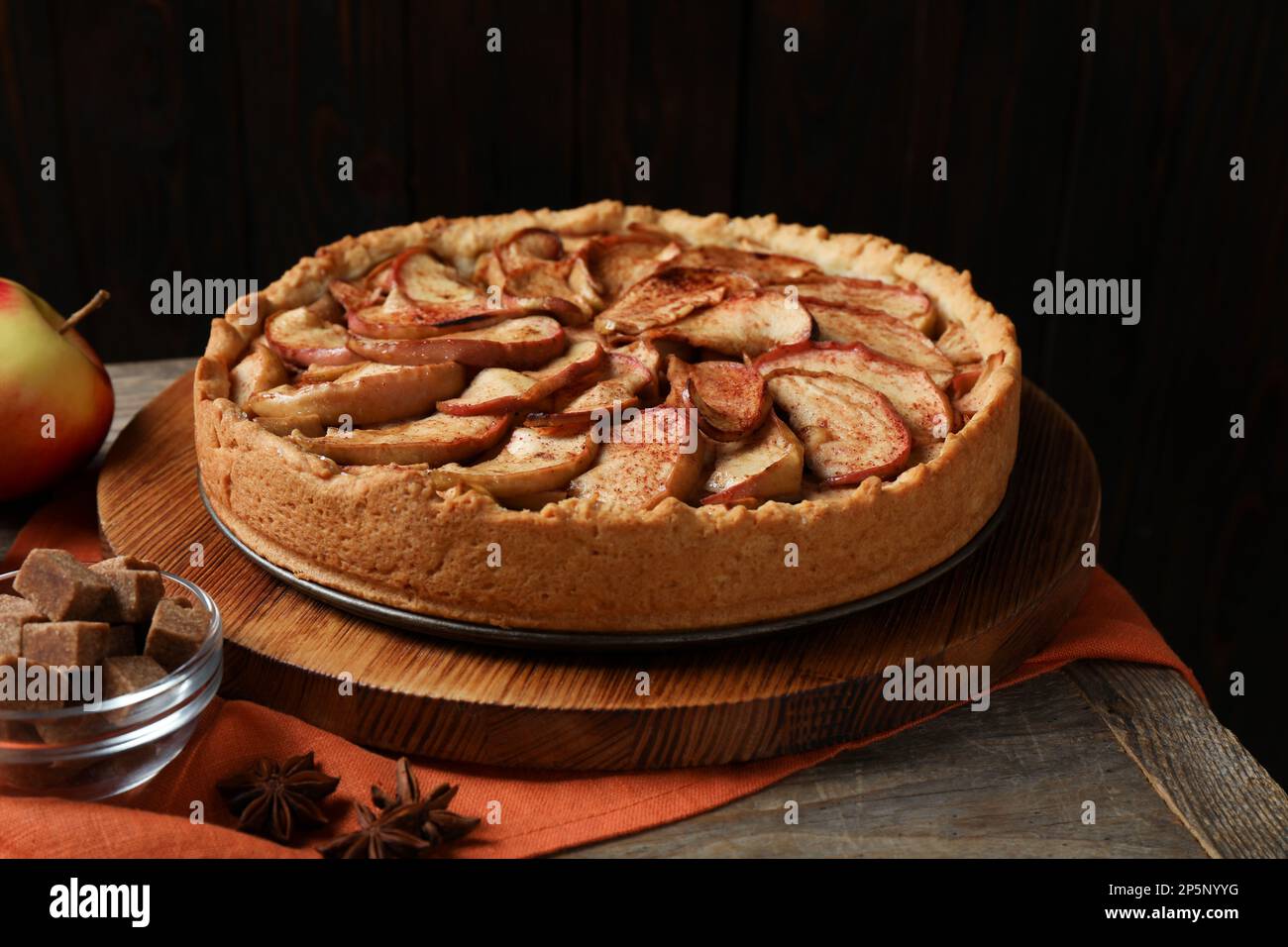 Delicious apple pie and ingredients on wooden table Stock Photo