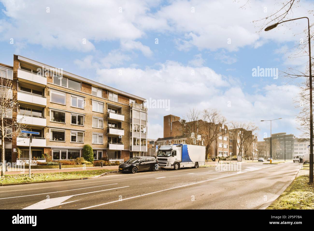a city street with cars parked on the side and buildings in the back ...