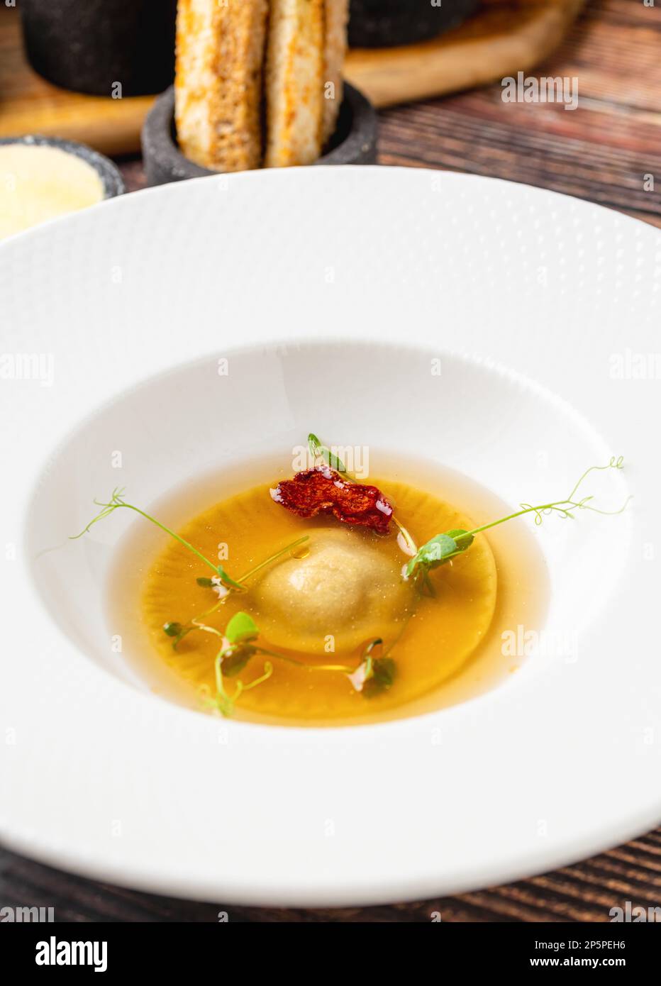Ravioli consomme on a white porcelain plate. Healthy eating concept