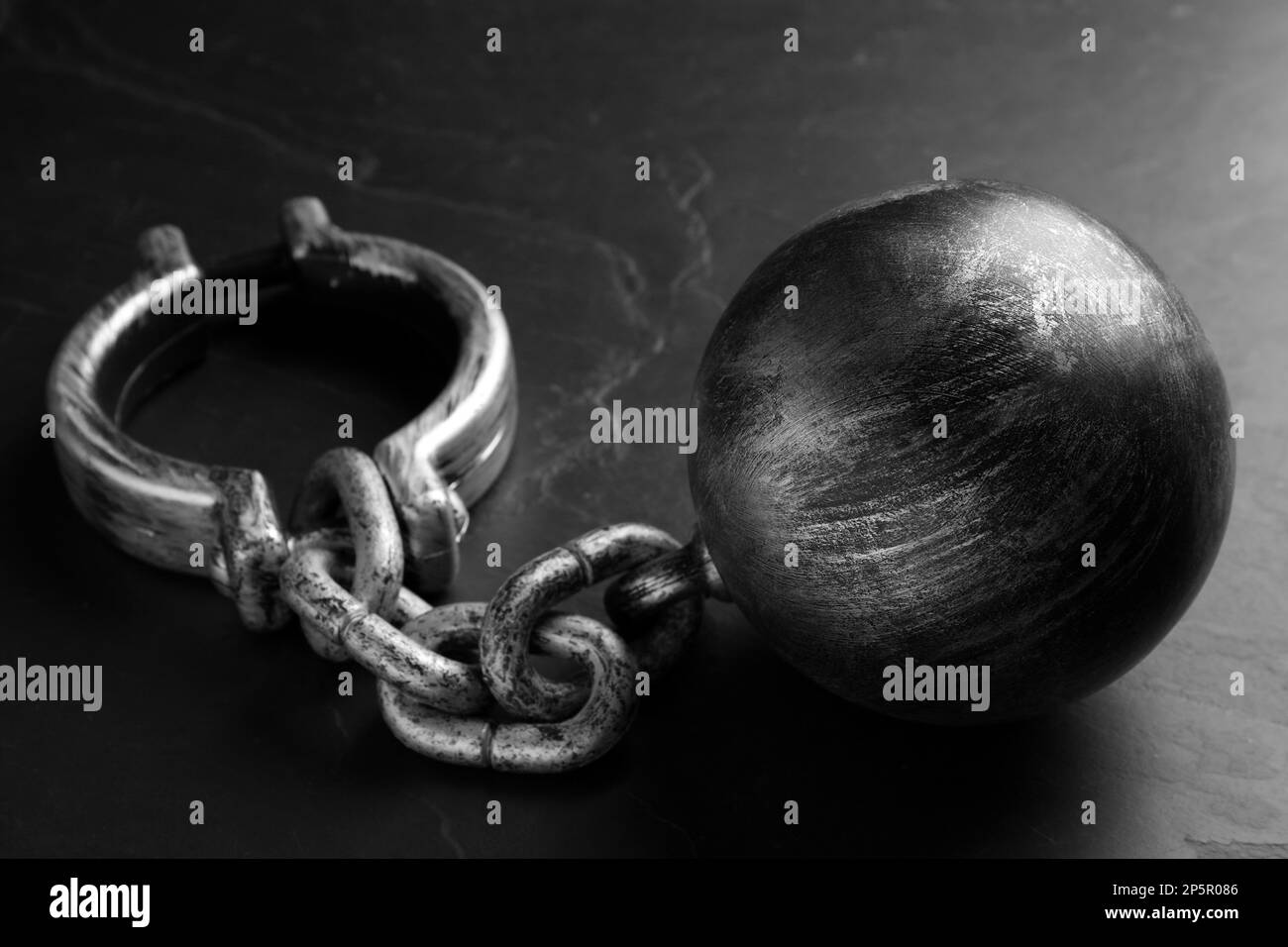 Prisoner ball with chain on black table Stock Photo Alamy