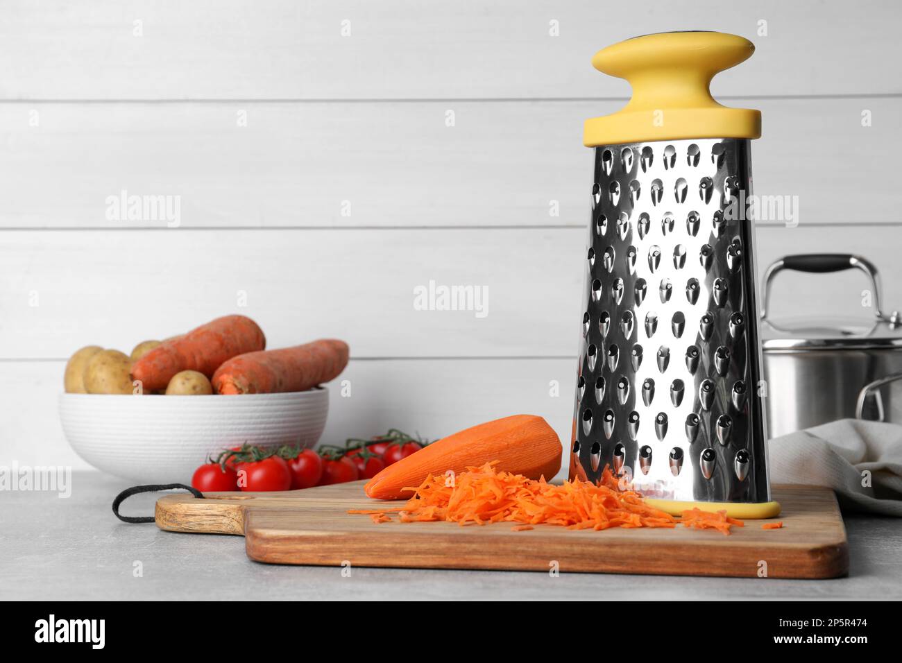 Grater and fresh ripe vegetables on table Stock Photo