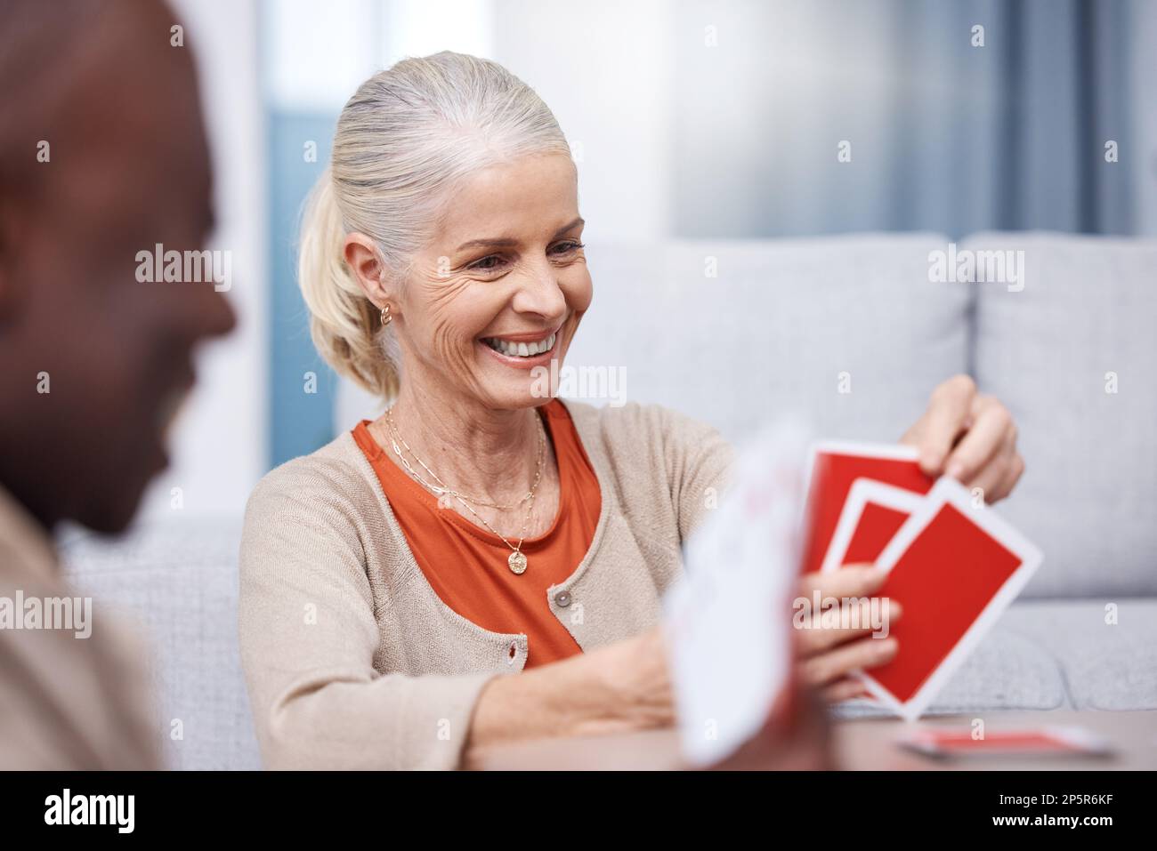 Playing cards, game and a senior woman in a retirement home having fun