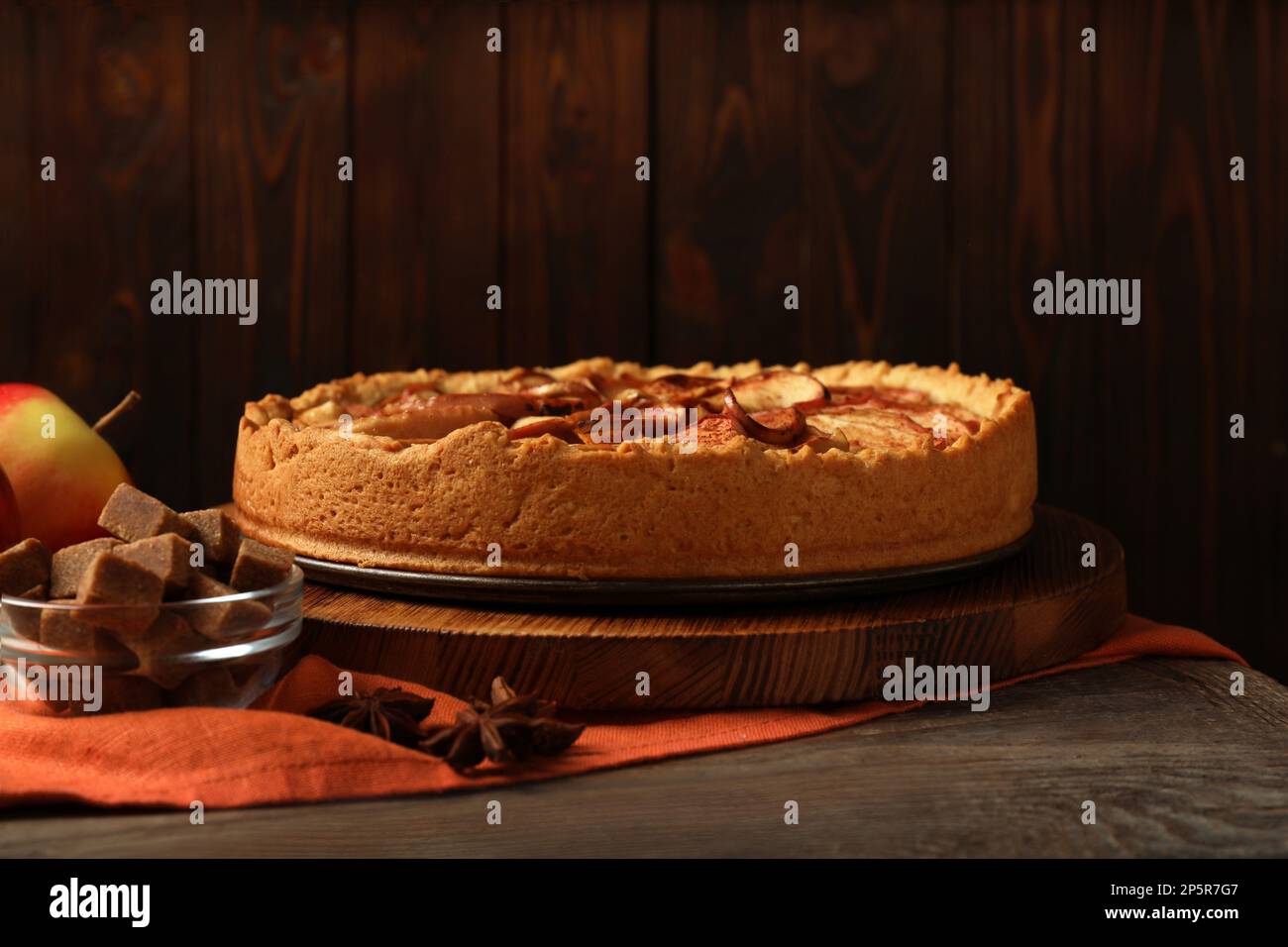 Delicious apple pie and ingredients on wooden table Stock Photo