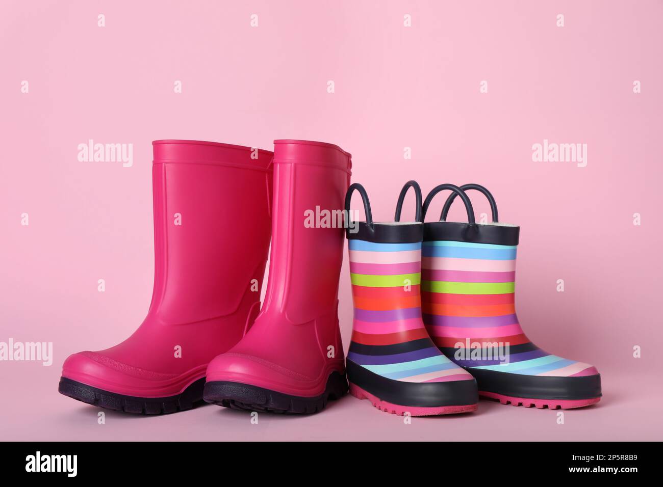 Two pairs of rubber boots on pink background Stock Photo Alamy