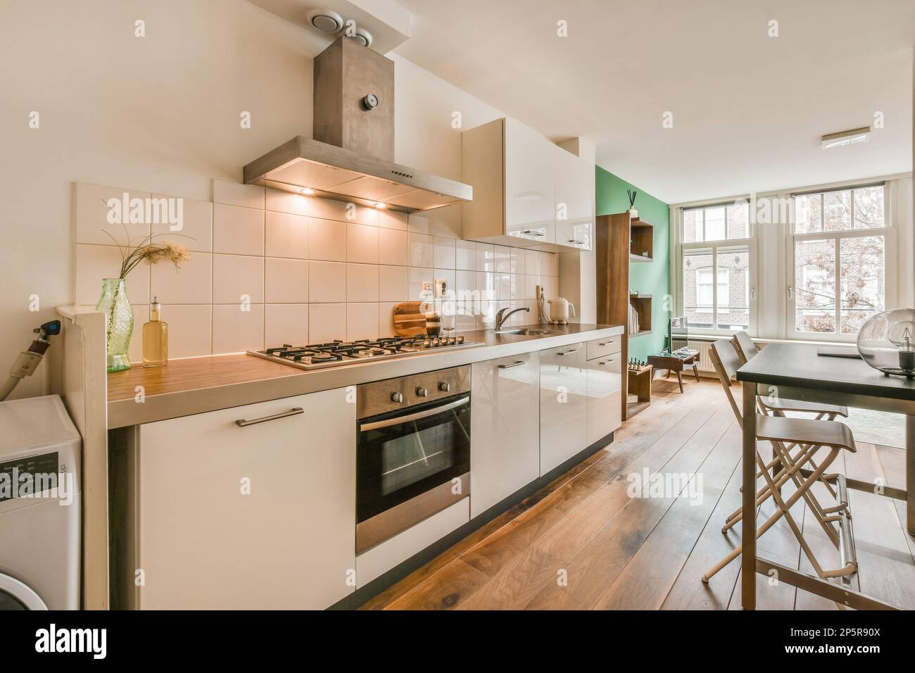 a kitchen with wood flooring and white cupboards, including an oven