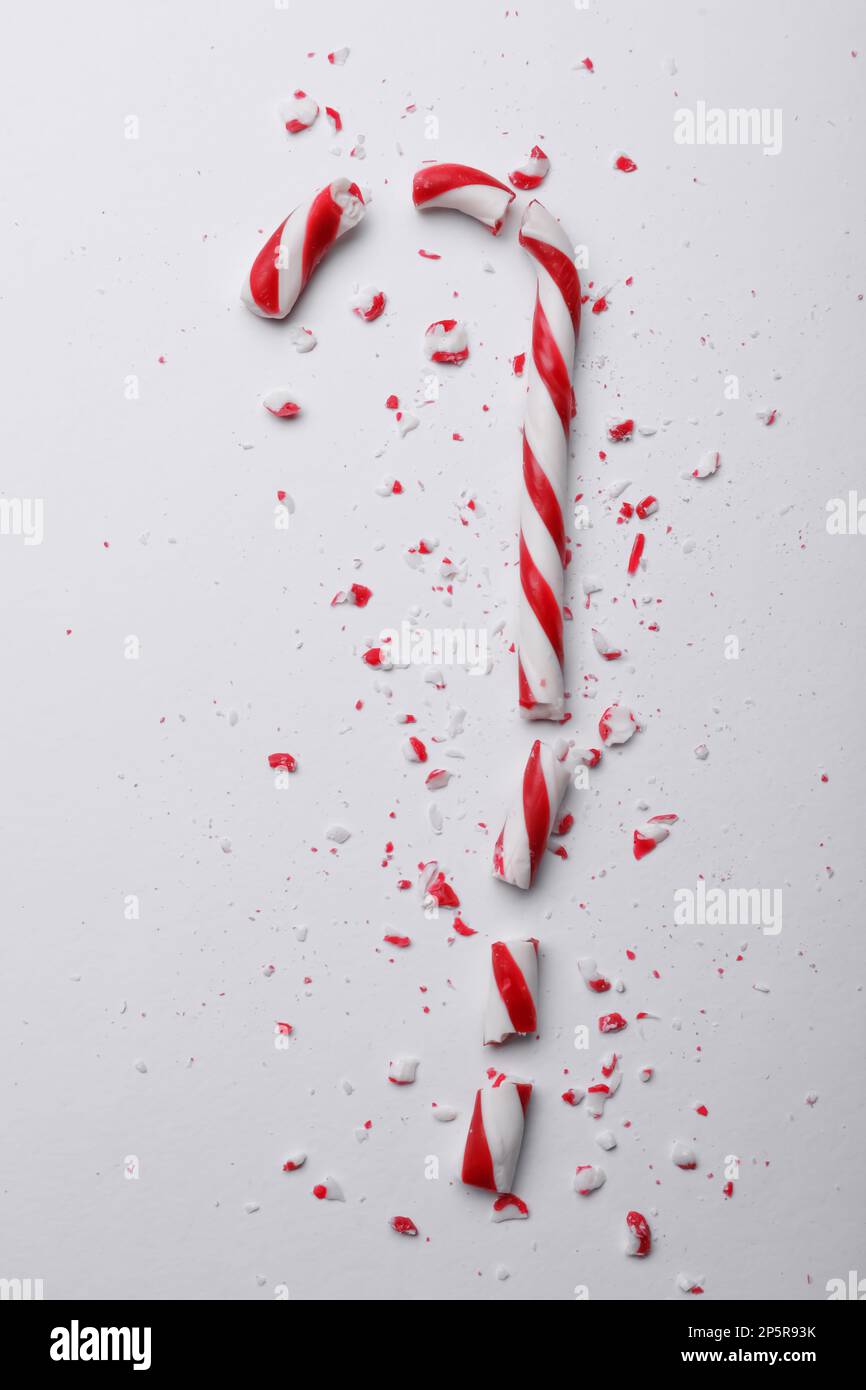 Broken sweet Christmas candy cane on white background, top view Stock Photo