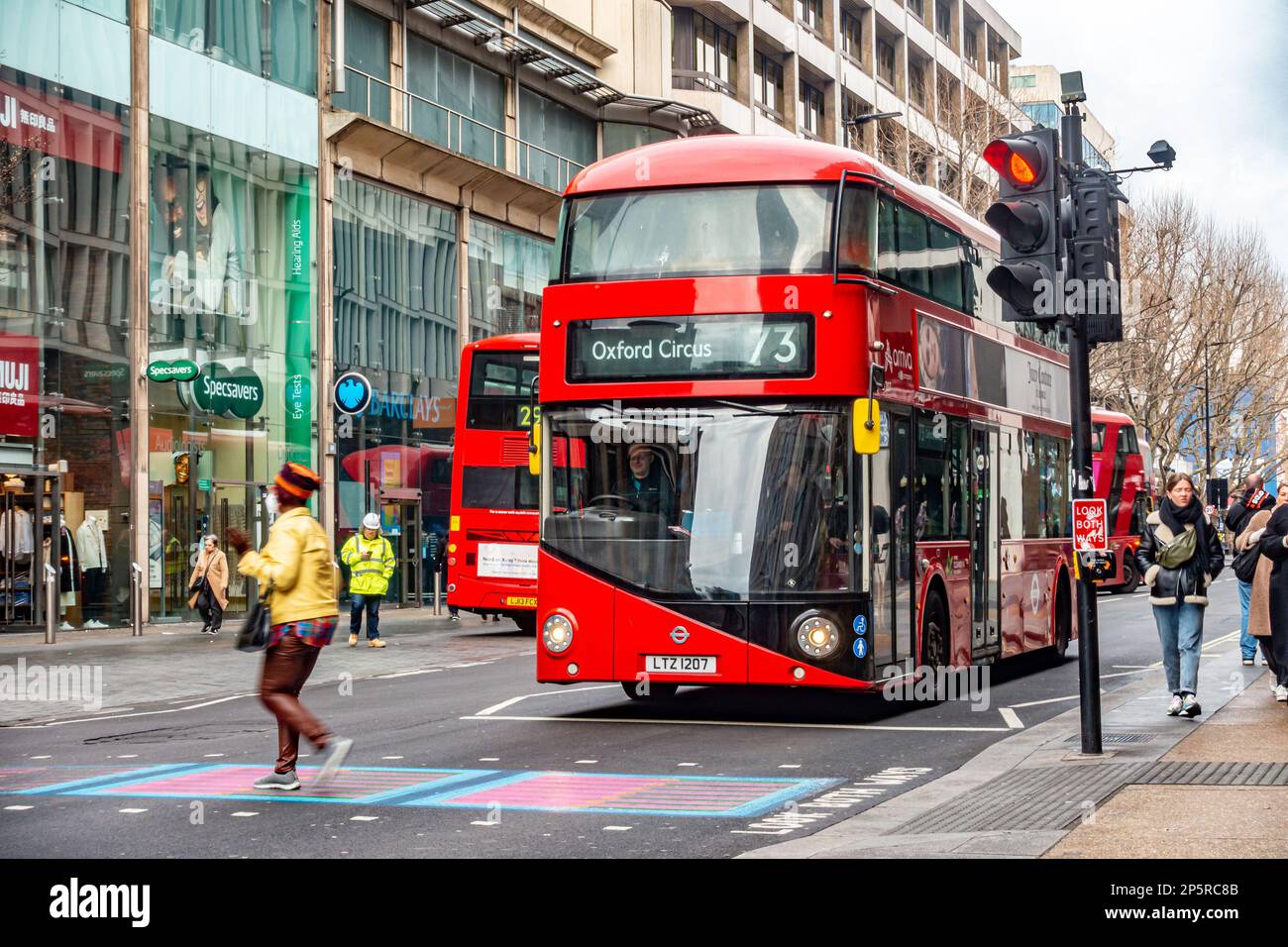 The no. 73 bus, a red double decker bus stops and waits at a pedestrian crossing on Tottenham court Road in London, UK Stock Photo