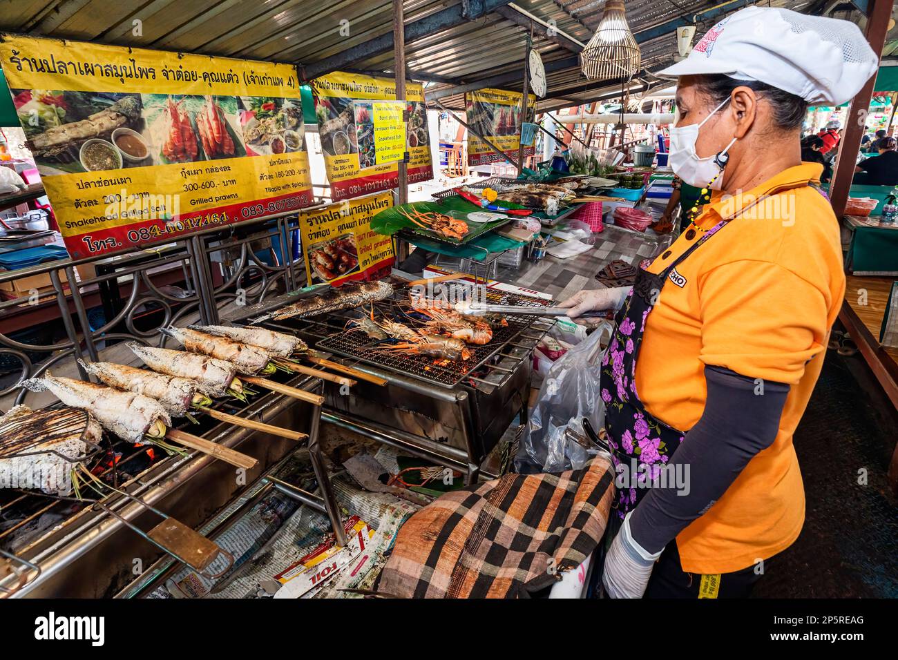 A food vendor cooking with a giant wok at the Taling Chan floating market  in Bangkok, Thailand Stock Photo - Alamy