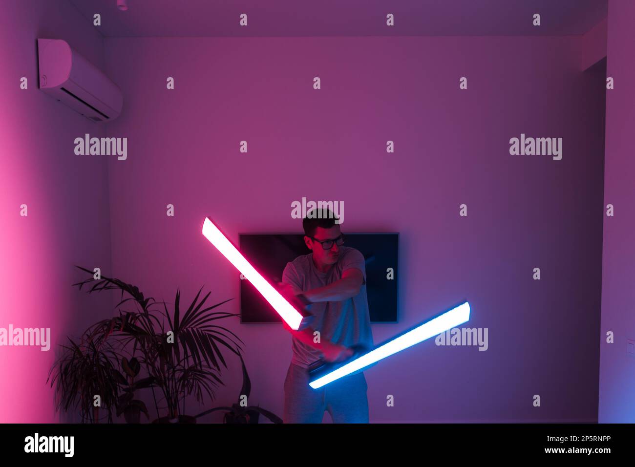 Mid adult man funny with led neon laser at home, samurai or Jedi Stock Photo Alamy