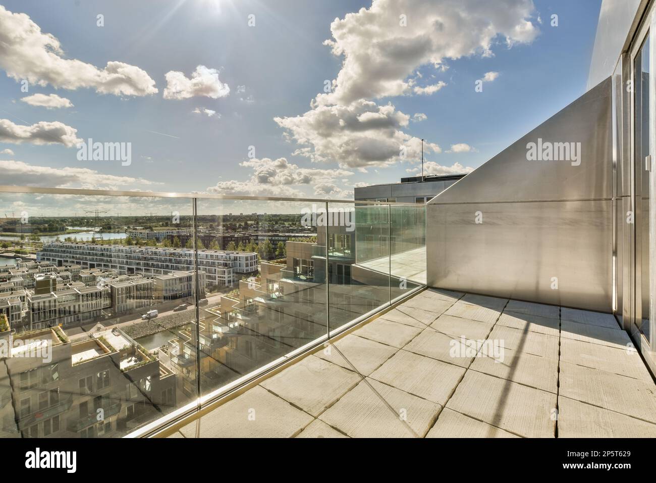 a city from the top of a building with clouds in the sky and sun shining through the window panoray Stock Photo