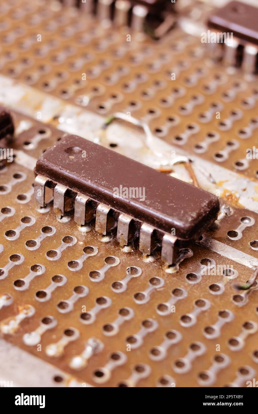 Old dirty yellow circuit board with transistors close up Stock Photo