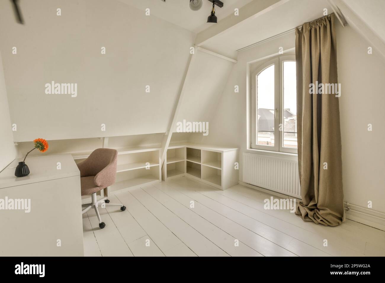 an empty room with a desk and chair in front of the window that looks ...