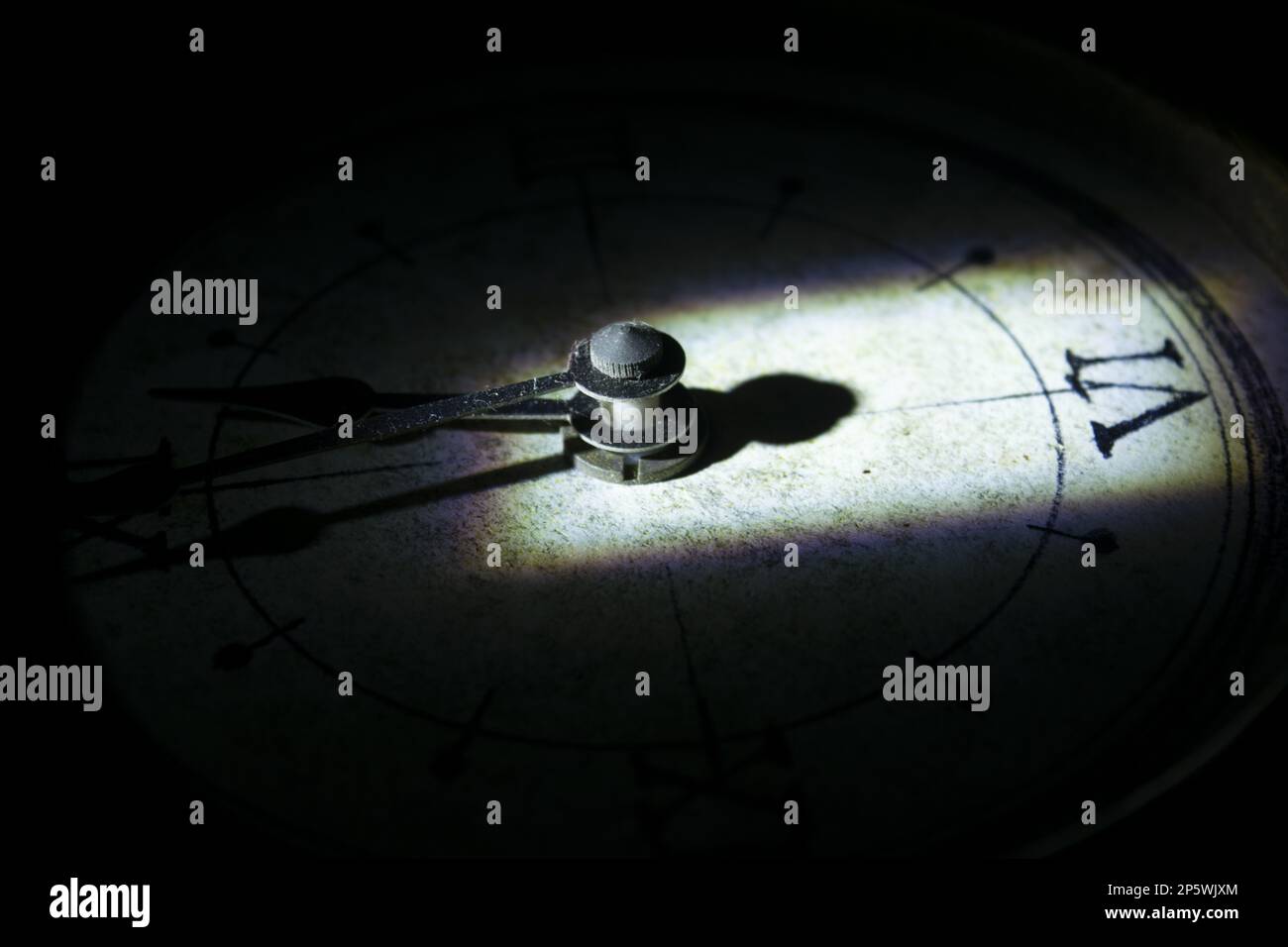 concept of time with the face of an old wall clock in directional light ...