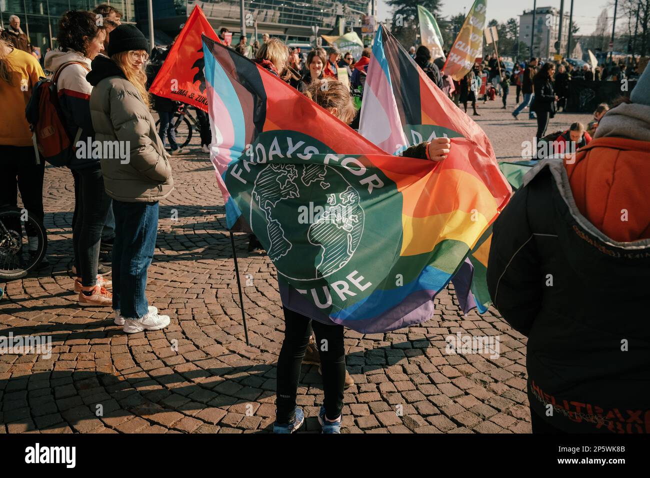 Darmstadt, Germany - 03.03.2023 - Fridays for Future Global Climate Strike, A Child with a big rainbow flag of Fridays for Future Stock Photo