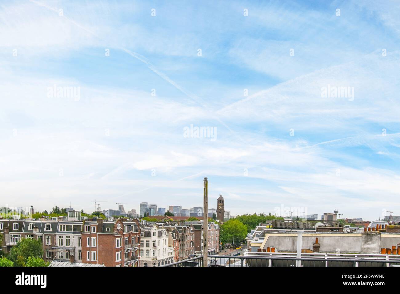 Amsterdam, Netherlands - 10 April, 2021: an urban area with buildings and trees in the fore, taken from a high angle on a clear blue sky day Stock Photo