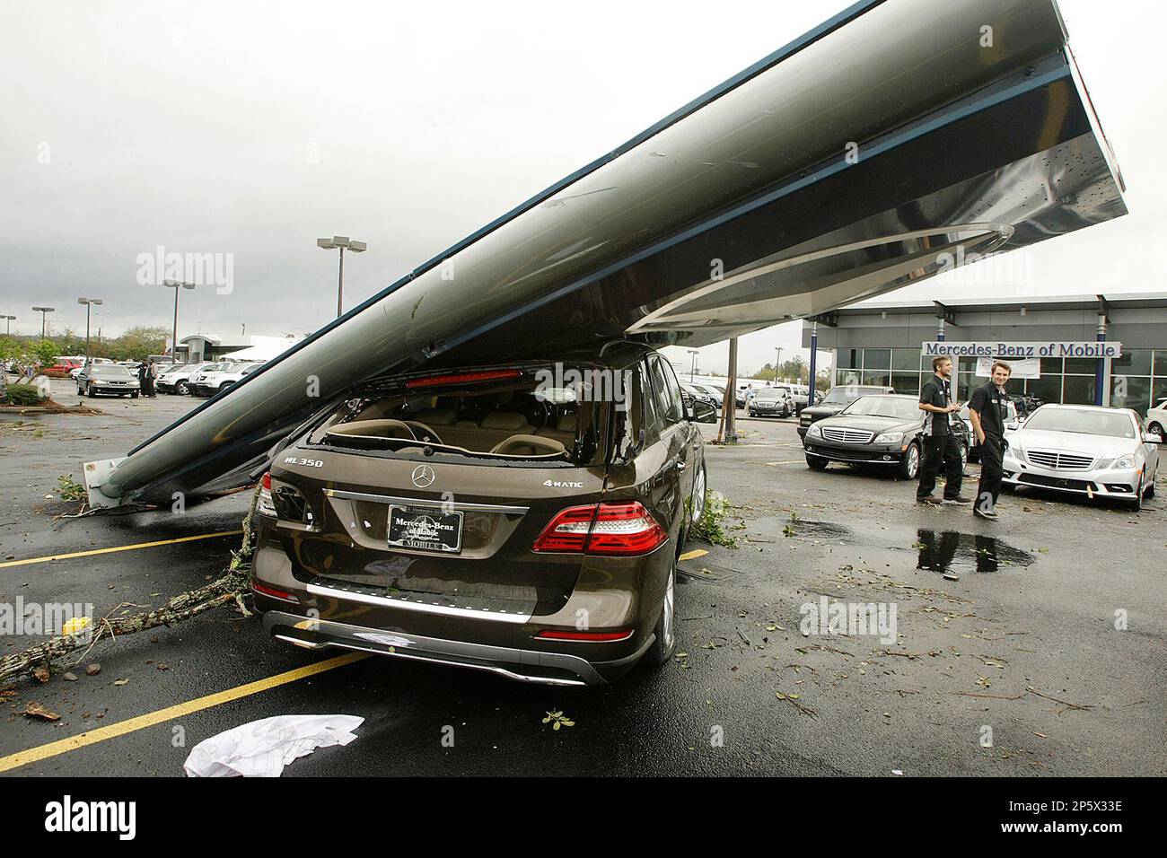 A car on the lot of MercedesBenz of Mobile in pinned under debris