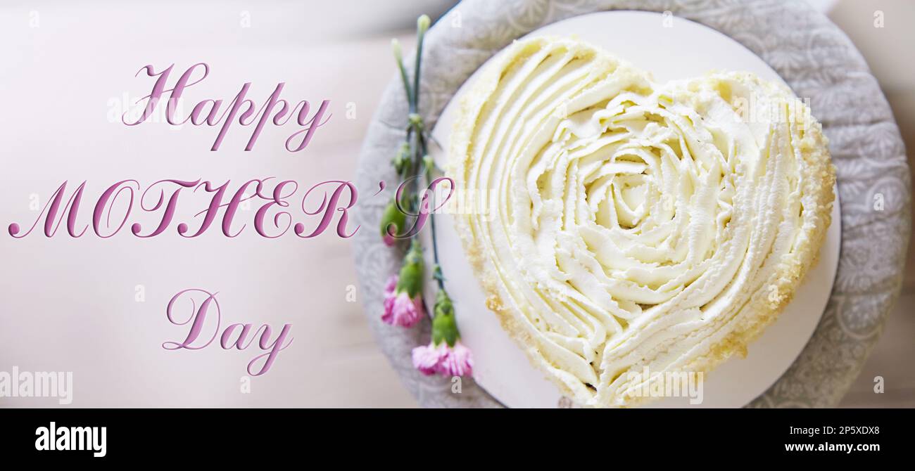 Happy Mothers Day extra wide banner with heart shaped cake. Stock Photo