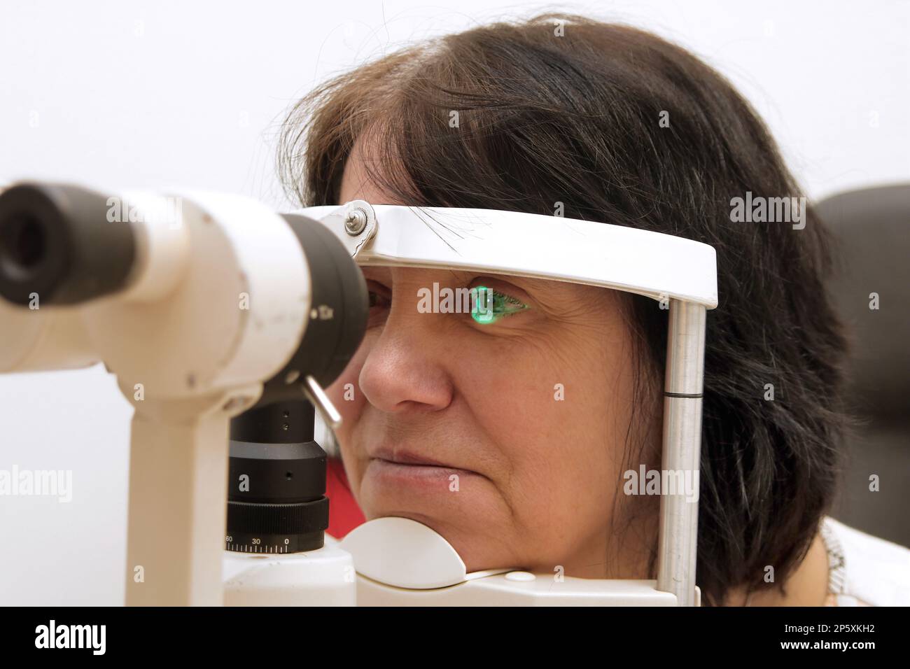 woman at the optician with slit-lamp microscope Stock Photo