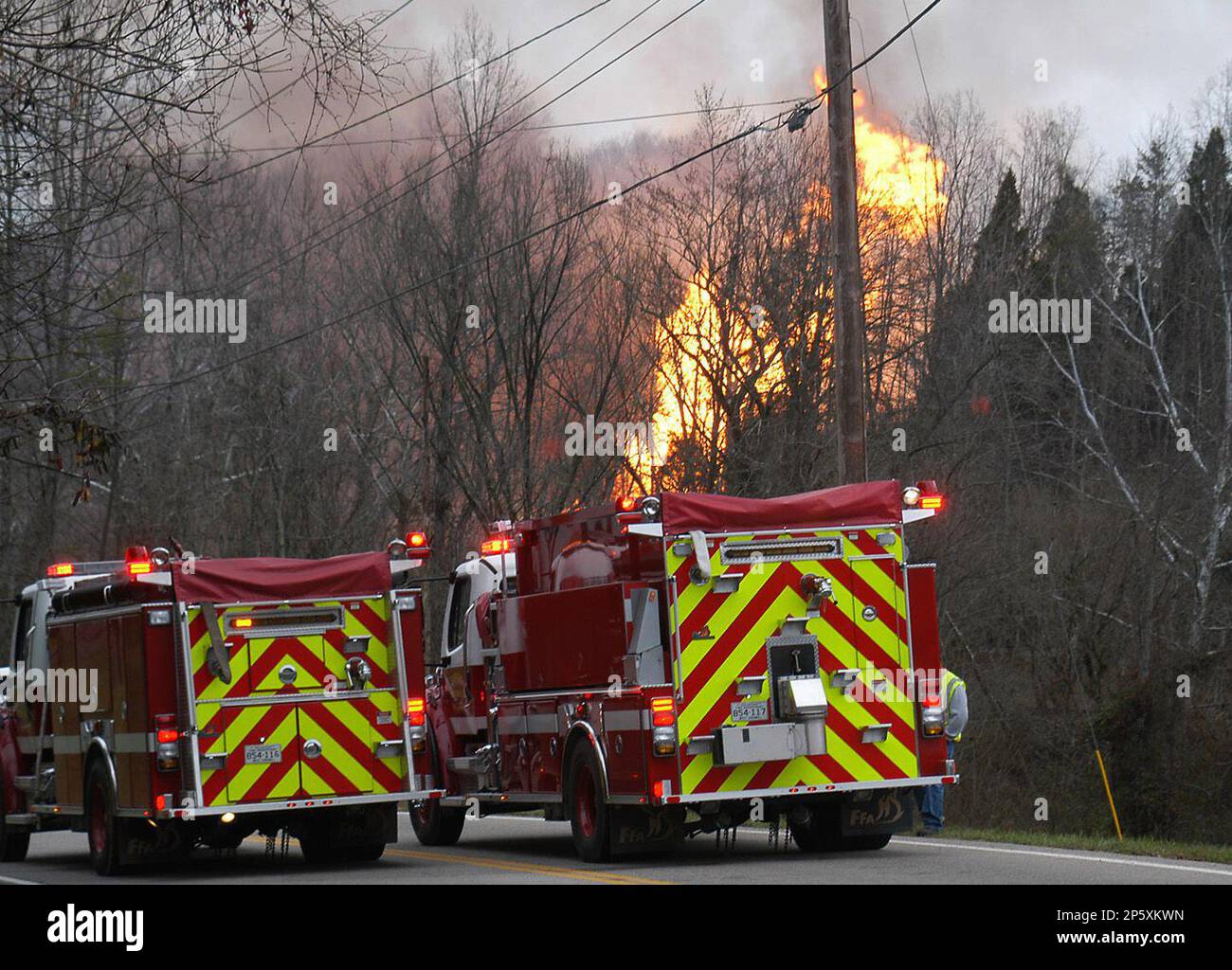 Firetrucks are ready as flames from a gas line explosion riase near