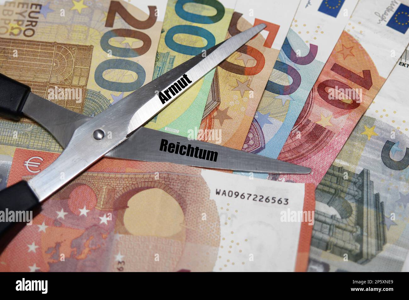 Euro bills with scissors, lettering Armut and Reichtum, poverty and richness, gap between the poor and rich Stock Photo