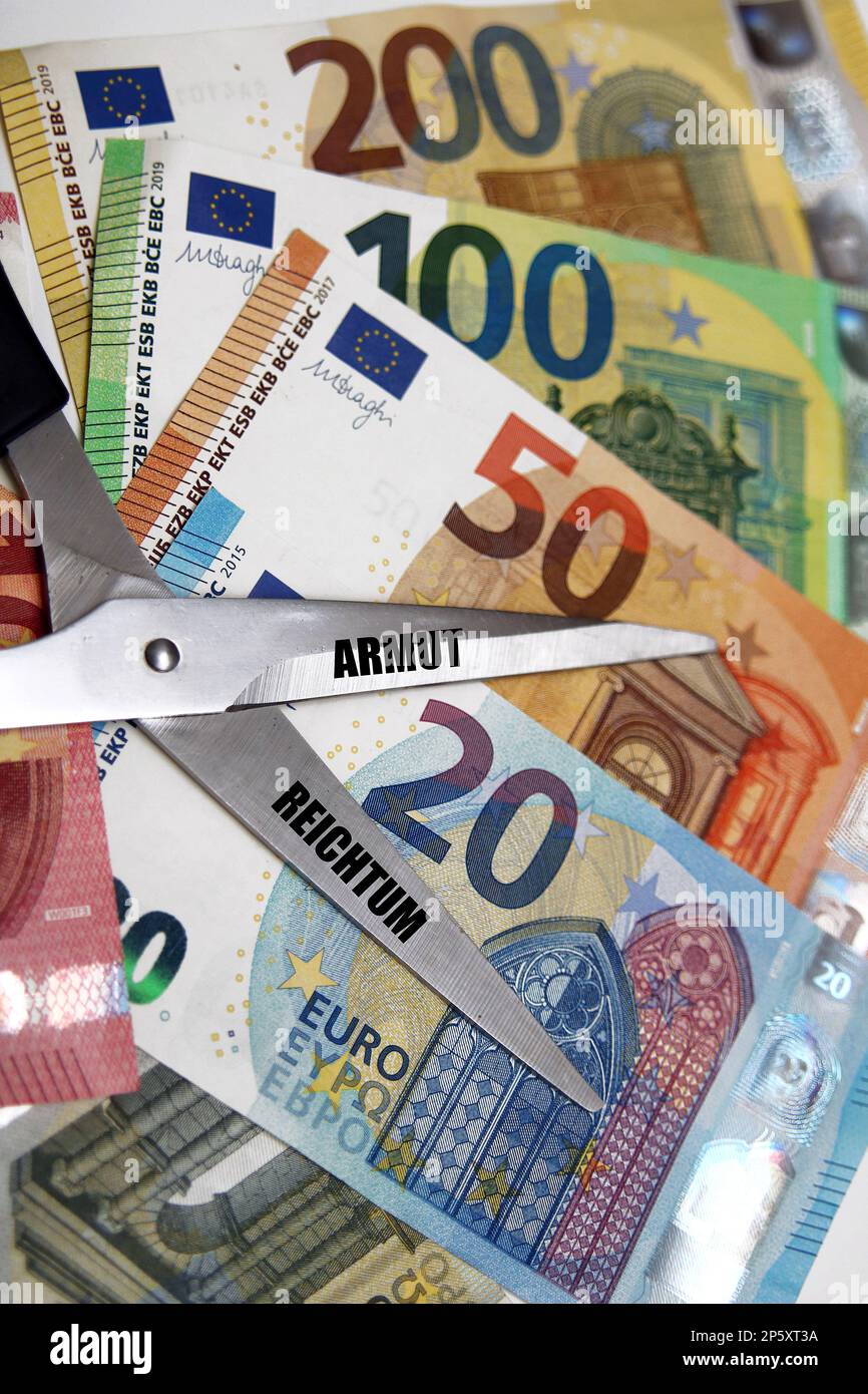 Euro bills with scissors, lettering Armut and Reichtum, poverty and richness, gap between the poor and rich Stock Photo