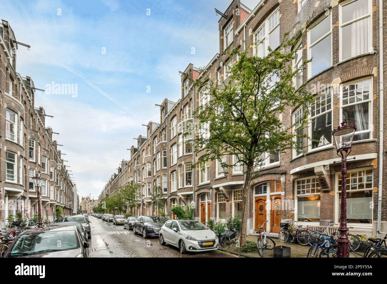 a city street with cars parked on the side and buildings in the back ...