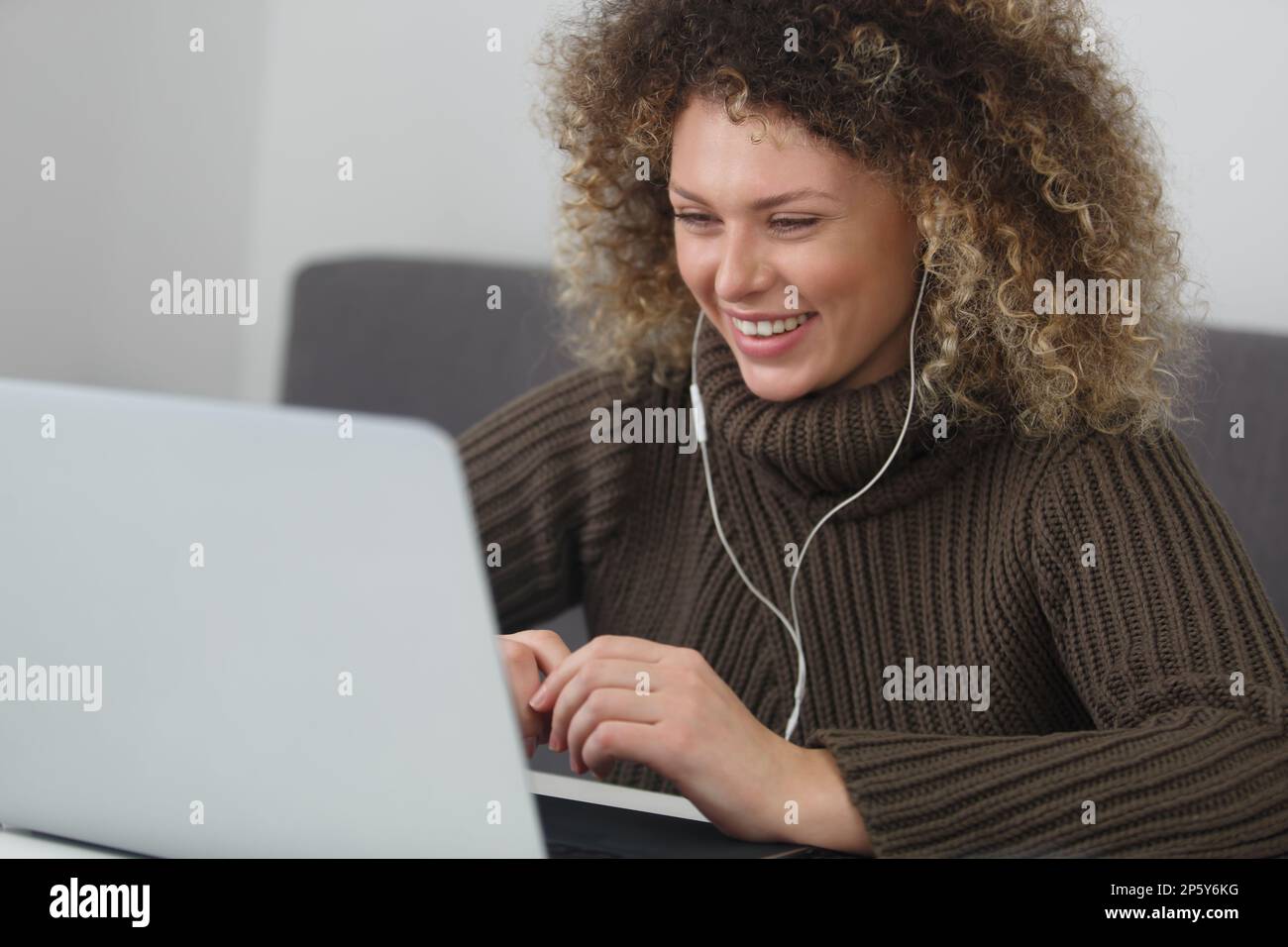 Happy young woman with curly hair wearing a headset and communicating