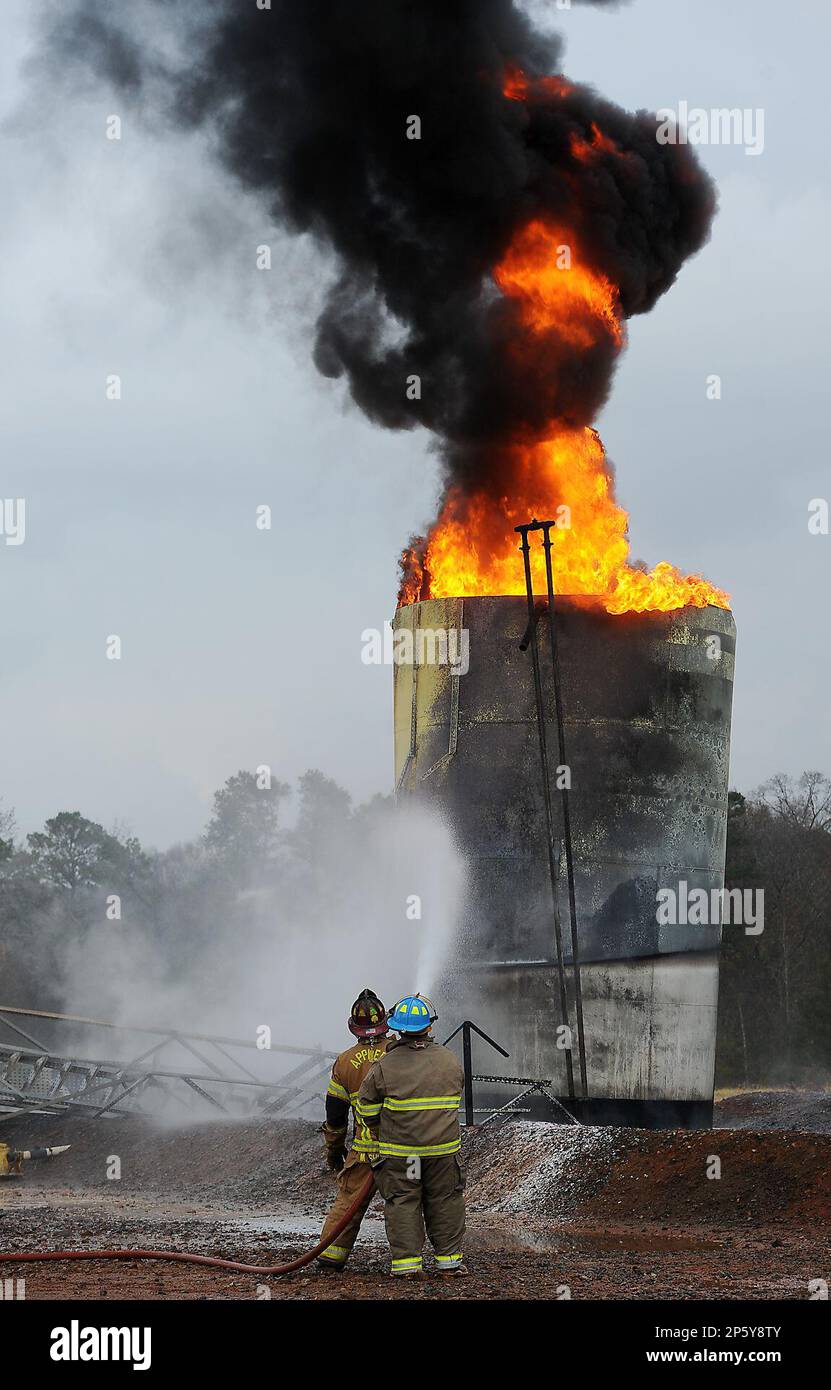Firefighters from three volunteer departments use suppressant foam to  extinguish a fire in a salt water storage tank at a natural gas well near  Nacogdoches, Texas, on Tuesday, Dec. 4, 2012. Katie